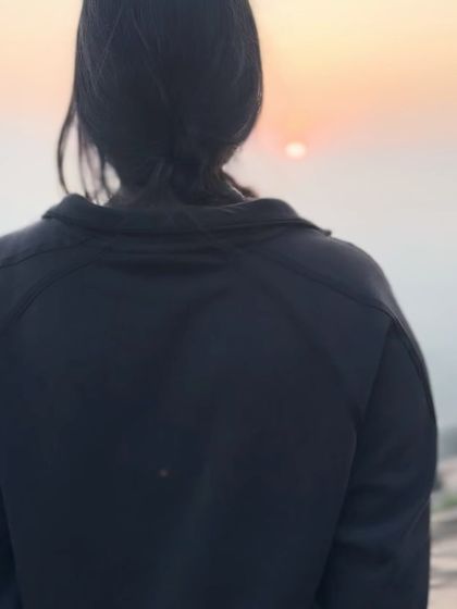 A close-up of a trekker watching the sunrise, a moment of quiet reflection.