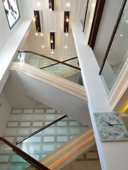 Views of different staircase designs, one with a multi-level view and another with classic marble steps and a wood-and-glass railing.