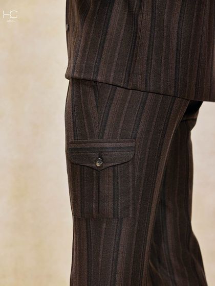 A detail shot of the striped trousers, focusing on the unique cargo-style pocket. It’s a small detail that adds a functional, contemporary edge to a classic pattern.