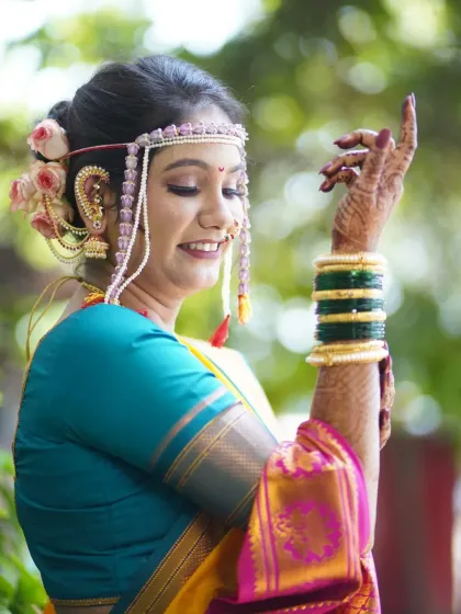 A graceful pose showing the bride's mehndi, bangles, and her elegant hairstyle adorned with flowers.