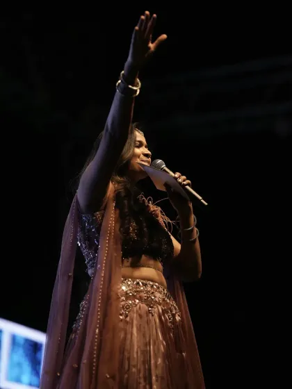 A powerful shot from the stage, engaging with the audience during the Sangeet performances.
