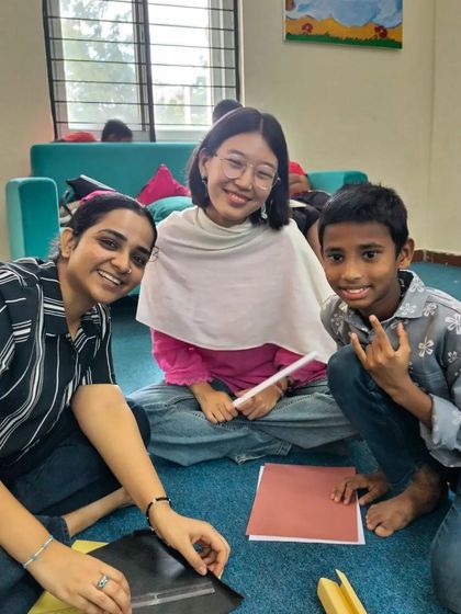 A group of volunteers and children work together on a friendship day craft. These sessions are about more than just stories; they are about building a supportive and caring community.