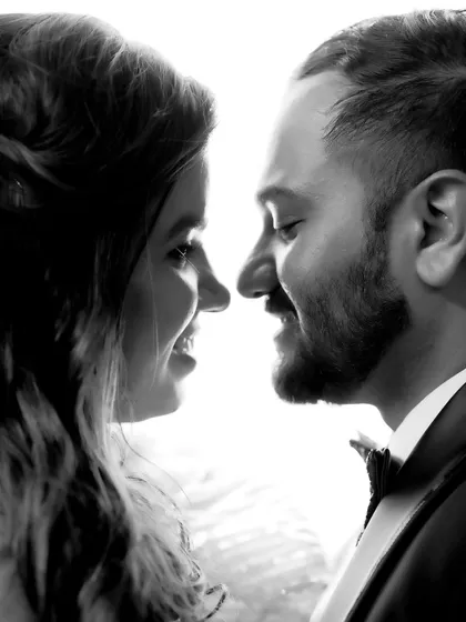 A classic black and white silhouette shot, focusing on the couple's profiles and the moment just before a kiss.