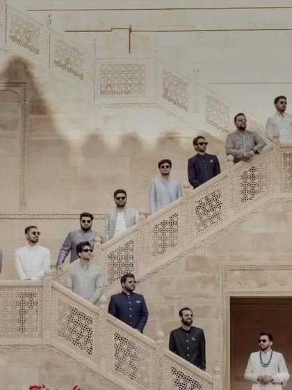 The groom's squad, looking dapper and ready for the celebration. This stylish group portrait on the intricately carved staircases of Suryagarh captures the cool, regal vibe of the wedding party.