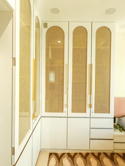 Another angle of the white and rattan wardrobe, showing how it fits perfectly into the corner to maximize space.