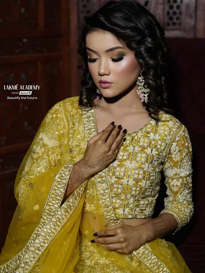 Another angle of this beautiful yellow-themed look, highlighting the soft curls and glowing skin. Our training is holistic, combining hair and makeup skills for a complete look.