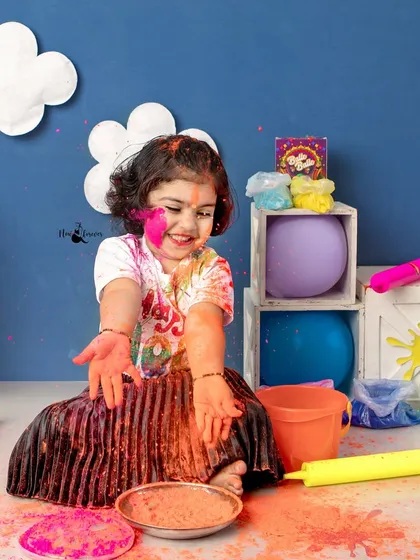 With a handful of colors, this little one is ready to play! The vibrant setup and her happy expression perfectly capture the fun spirit of Holi.