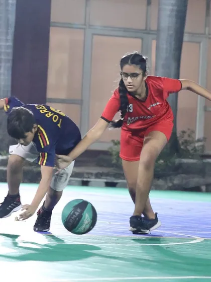 A girl plays tough defense, trying to steal the ball. Our sessions cover all fundamentals, including defensive stances and techniques.