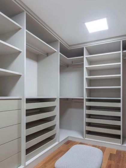 The interior of a walk-in closet under construction. This image shows the custom shelving, drawers, and dedicated sections for shoes, providing a clear view of the organized storage possibilities I can create.
