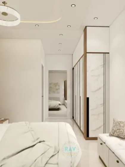 Another angle of the minimalist bedroom, showing the window-side seating and the large wardrobe with a clean, white finish.