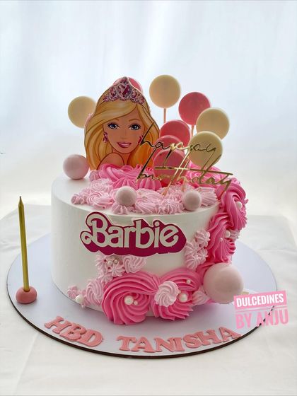 A chic Barbie cake with soft pink swirls and elegant balloon toppers.