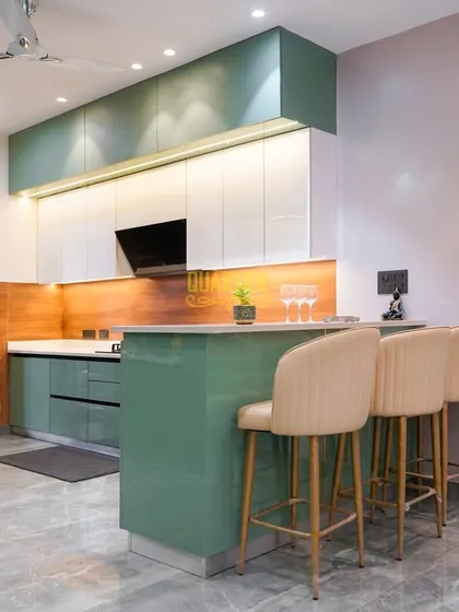 This modular kitchen in Noida is the heart of the home, blending function and style. I used a refreshing green and white color scheme, handle-less cabinetry for a sleek look, and a functional breakfast bar island that makes the space perfect for both cooking and socializing.