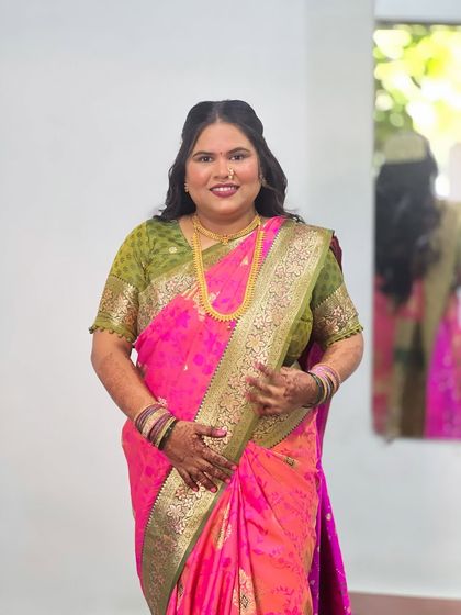 A full view of the client's look. The simple hairstyle balances the vibrant colors and rich texture of her traditional saree.