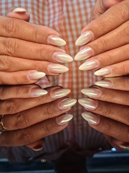 A beautiful set of pearly, off-white stiletto nails that look both elegant and trendy.