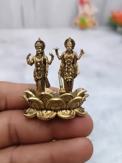 Yeh haath mein rakhi hui Lakshmi Vishnu ki murti hai, jo ek kamal ke phool par khade hain.