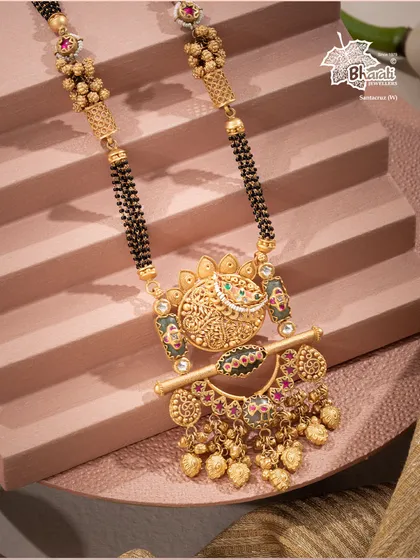 We believe the Mangalsutra is a statement of love, sealed in emerald and gold. This heritage design reimagines the sacred thread as a piece of high art, featuring a beautifully carved gold pendant studded with radiant emeralds and intricate details, a symbol of devotion refined through generations.