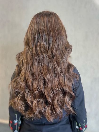 This look showcases the beauty of a global color with subtle highlights. The brown base is enriched with lighter strands that add dimension and a touch of brightness.