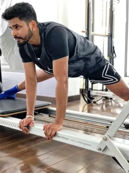 Cricket star Shreyas Iyer uses the reformer to work on a deep groin stretch, essential for hip mobility and preventing injuries in a sport that requires explosive lateral movements.