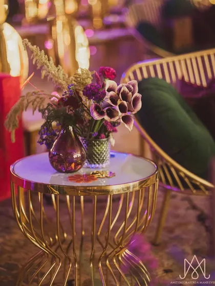 A small but impactful detail. A beautiful floral arrangement on a gold wireframe side table adds a pop of color to a lounge seating area.