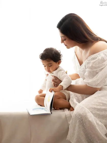 Story time with mom. A mother and her baby share a book in this sweet, candid moment, beautifully lit by the window.
