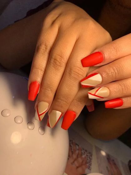 A modern, color-blocked design using matte red and nude polish with clean, geometric lines.