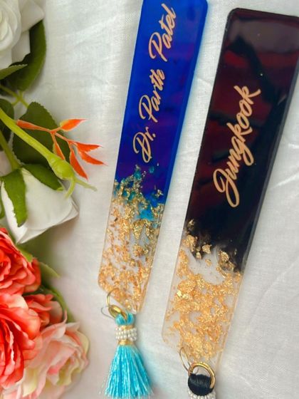 A closer look at the two-tone design of these custom bookmarks. The clear resin with gold leaf transitions beautifully into the solid black and blue colors.