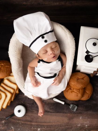 A sleepy smile from our newborn chef, perhaps dreaming of his next culinary creation.