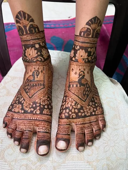 A classic bridal feet design with peacock and floral patterns. The intricate details cover the feet beautifully, perfect for a traditional bride.