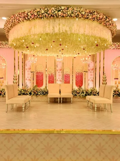 Here is a full view of an elegant pastel stage I designed for an engagement. The setup features a massive floral chandelier, soft pink backdrops with intricate arches, and plush seating, creating a sophisticated and romantic focal point.