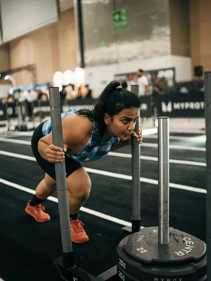 Strength isn't just about barbells. This is me during a Hyrox competition, a race that tests both strength and endurance. My functional fitness coaching incorporates varied movements like sled pushes to build real world strength that makes you ready for any challenge.