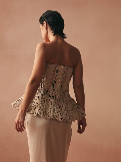 The back of the Karov corset, showing the intricate, knotted cords laced into sculpted cutwork. The paisley motifs are handcrafted on a cotton base with zari threads.