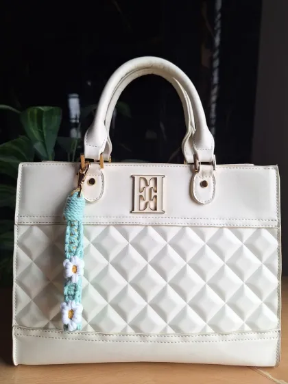 This daisy bag charm in a cool mint green is perfect for adding a fresh, summery vibe to your accessories.