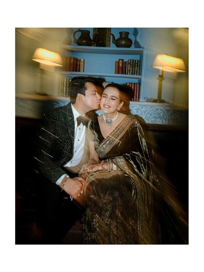 A blurry, dreamy kiss in a cozy library setting. This artistic shot from the reception captures the romance and motion of the evening.