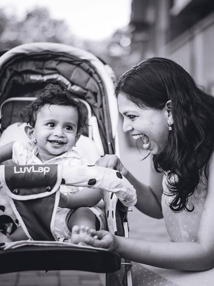 A mother and her baby share a moment of pure joy, captured in timeless black and white.