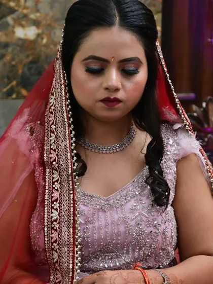 Another angle of the bride looking down, highlighting the details of her makeup and jewelry.