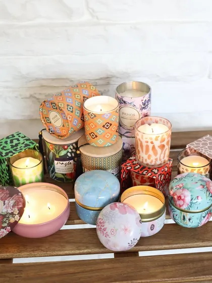 A beautiful array of our scented candles, showcasing the variety of prints, sizes, and styles in our collection. Each one is a small piece of art, designed to delight the senses.