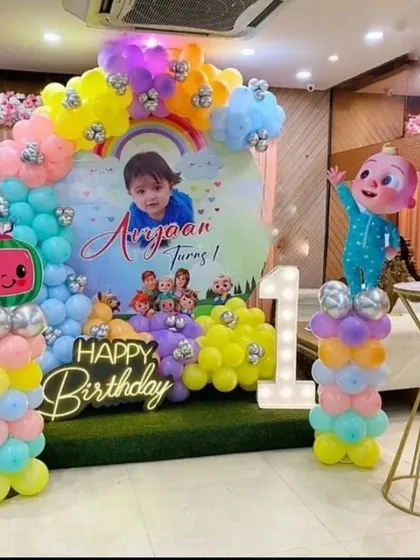 I create decorations based on popular kids' shows like this Cocomelon theme. The setup features a colorful balloon arch, character cutouts, and a personalized backdrop for the birthday boy's first birthday.