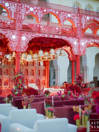 The combination of intricate red and white architectural details, lush floral arrangements, and the grandeur of the setting created a truly magical ambiance for this wedding ceremony.
