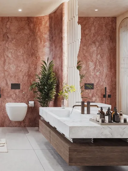 This view showcases a massive, monolithic double vanity in white marble, set against a backdrop of dramatic red stone walls.