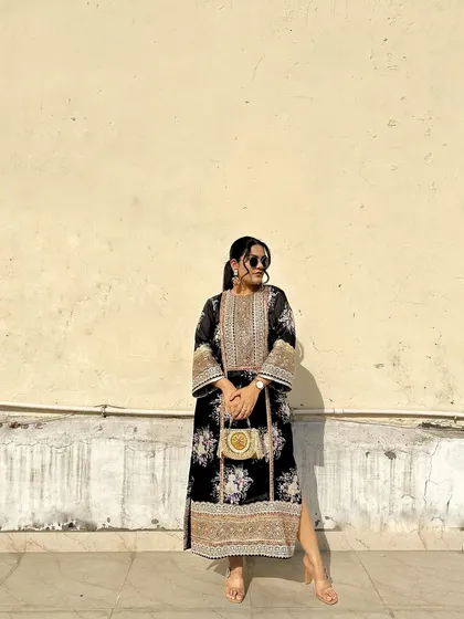 This pose highlights the side profile of the outfit and the elegant way the clutch is held, showing its versatility.