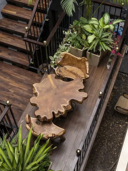 We believe transitional spaces should be as meaningful as destinations. On this staircase landing, we created a unique hanging garden with a live-edge wood table, transforming a simple passage into a serene nook for reflection and connection.