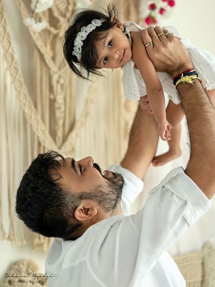 A duplicate of a father's joyful moment, lifting his daughter into the air.