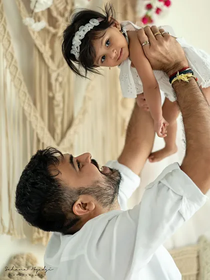 A duplicate of a father's joyful moment, lifting his daughter into the air.