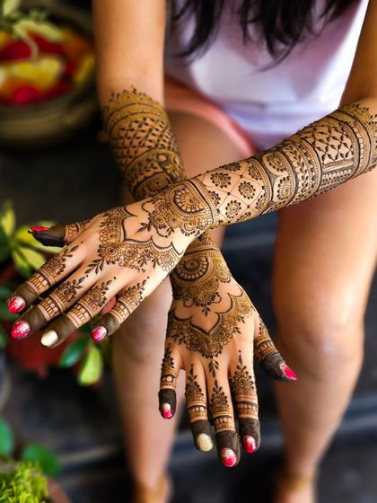 A classic crossed-hands pose showing a beautiful bridal design.