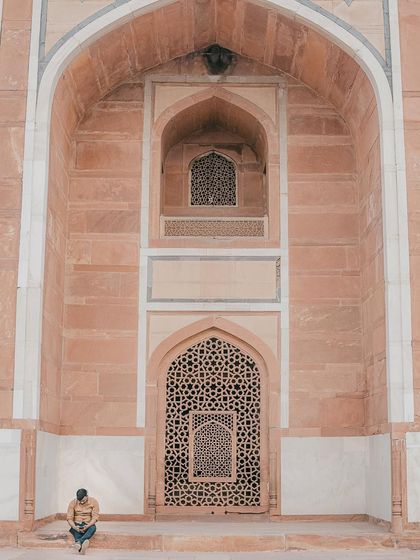 A solitary figure against the intricate patterns of Humayun's Tomb. This shot emphasizes symmetry and scale, creating a powerful and contemplative image.