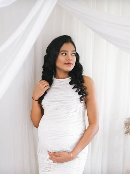 A beautiful solo portrait of the mom to be. The soft white fabric and her thoughtful expression create a dreamy and peaceful image.