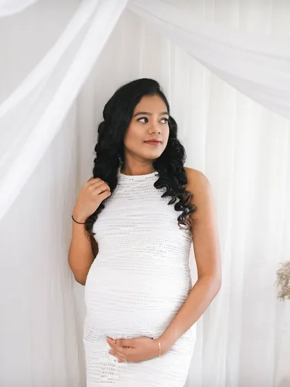 A beautiful solo portrait of the mom to be. The soft white fabric and her thoughtful expression create a dreamy and peaceful image.