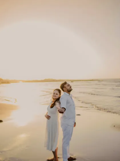 A beautiful portrait of the couple holding hands against the setting sun. The composition is both simple and powerful, symbolizing their partnership.