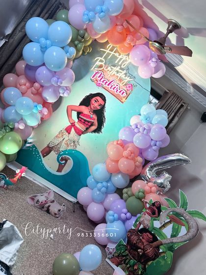 A wide shot of the Moana birthday setup, showing how the balloon arch frames the central backdrop.