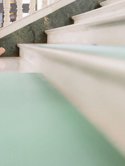 An artistic, low-angle shot of a child walking up the stairs at the Gurudwara. It's a small, candid moment that adds a touch of innocence and life to the wedding story.